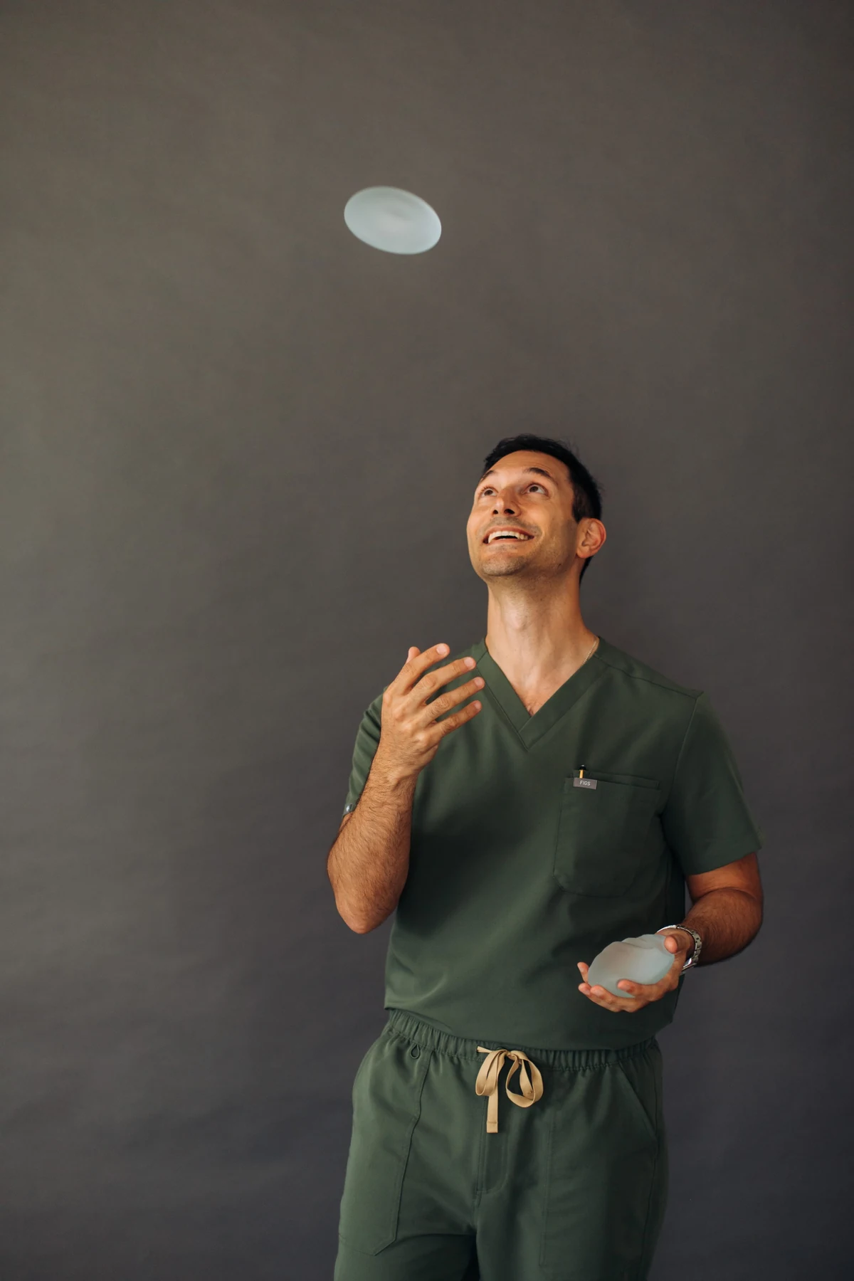 Dr. Corey tossing a breast implant model into the air