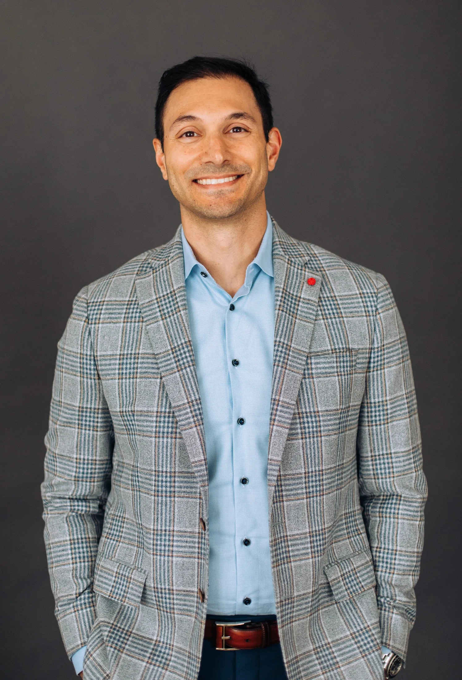 Dr. Samuel Corey in a plaid jacket and light blue shirt