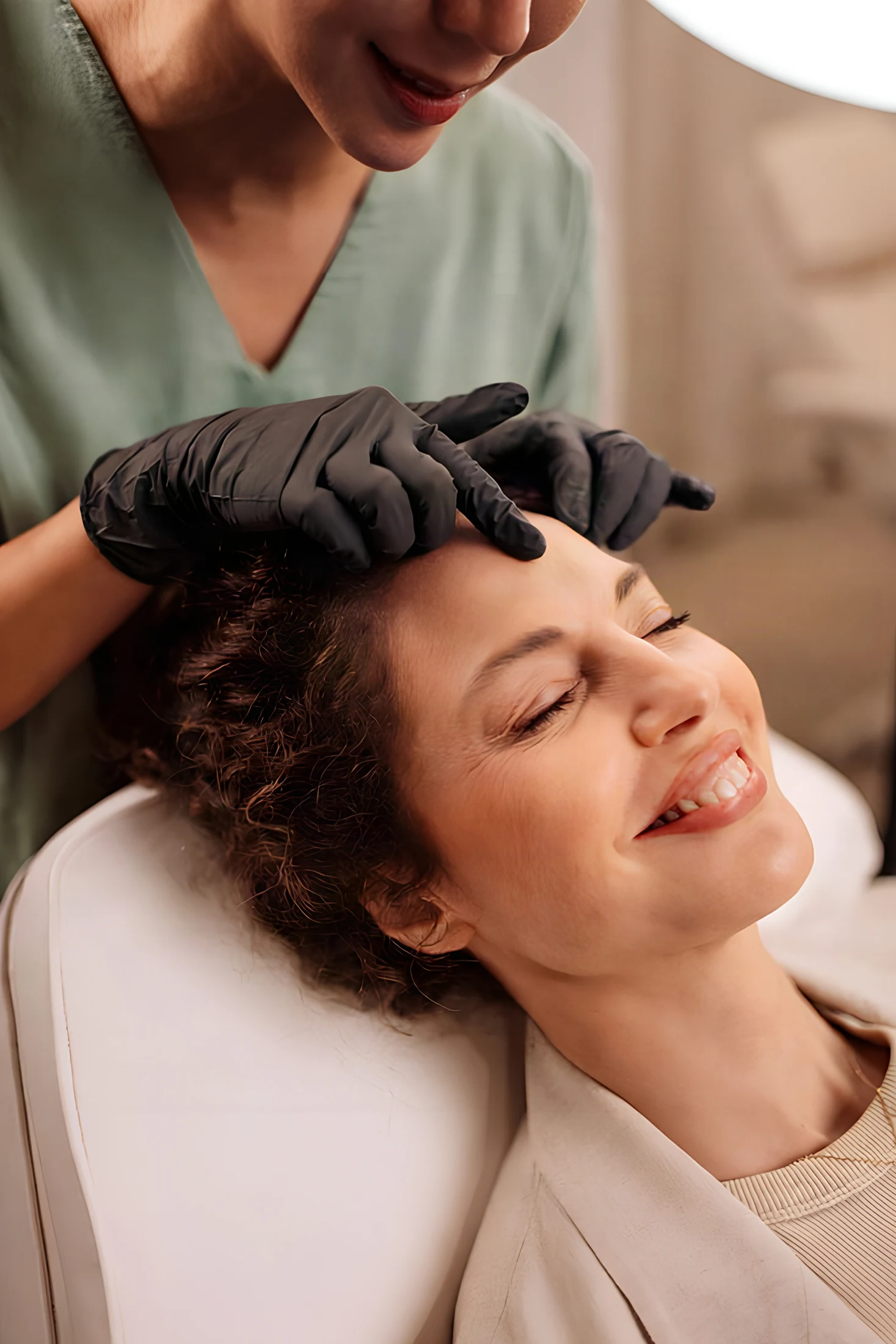 A provider gently assessing a woman's face before aesthetic treatment