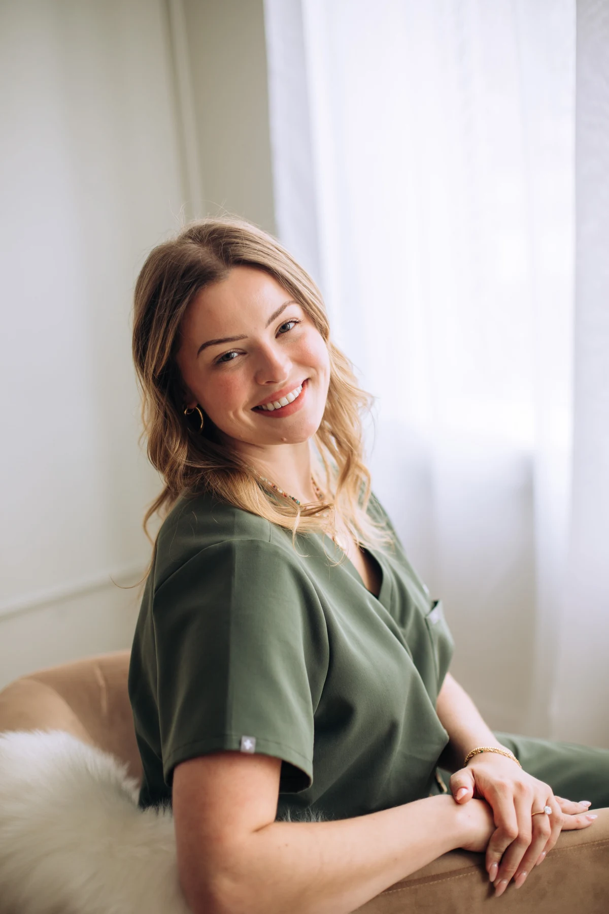 A smiling Summit team member seated beside a window
